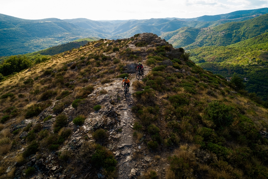 Au milieu des vallées cévenoles, deux vététistes descendent d'un sommet  sur un sentier monotrace