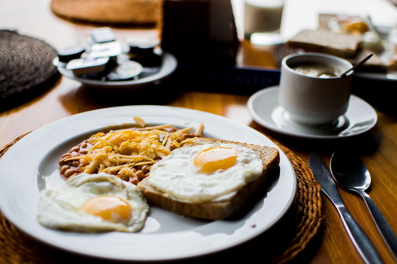 sur une table, une tasse de café et une assiette avec des céréales et dex oeufs